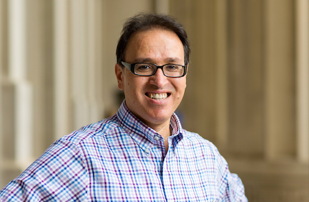Poet and translator Khaled Mattawa smiling in a colonnade.